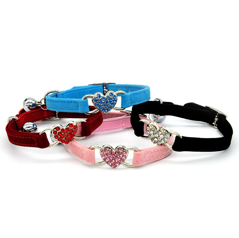 Adjustable safety cat collar with dainty heart charm, featuring a secure design and soft material for comfortable wear.
